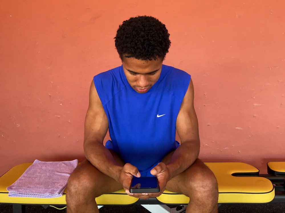 Athlete checking their phone after finishing a set